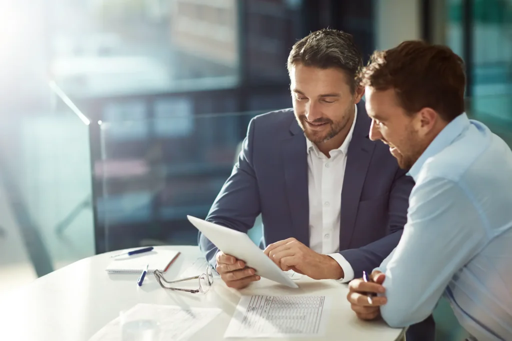 Image of empowerment consultant discussing growth objectives while pointing at a tablet computer